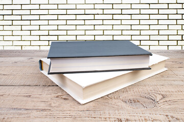 Wall Mural - open book. Composition with hardback books, fanned pages on wooden deck table and Brick wall background. Books stacking. Back to school. Copy Space. Education background.