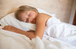 © JuLady_studio - A little girl with long hair is peacefully sleeping in a comfortable bed on a white pillow at the morning. Close up shot.It's perfect for projects related to family, childhood, or relaxation.