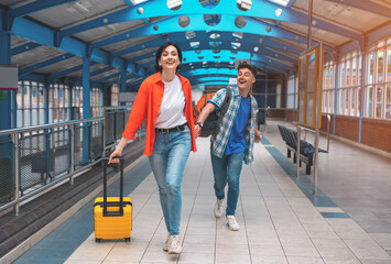 a young couple traveling together during their honeymoon, sitting in Interchange, waiting for bus, drinking coffee, chatting, reading news. Traveling together concept