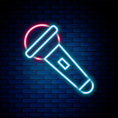 Poster - Glowing neon line Microphone icon isolated on brick wall background. On air radio mic microphone. Speaker sign. Colorful outline concept. Vector