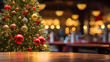 Mesa De Madera, Arbol De Navidad Y Decoraciones Navideñas Con Fondo De Bar O Restaurante Desenfocado Con Bokeh Dorado.