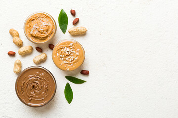 Glass jar with peanut butter on table background, top view space for text and close up