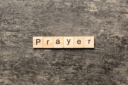PRAYER word written on wood block. PRAYER text on cement table for your desing, concept