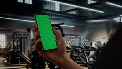 CU Caucasian man using phone in a gym, coaching training sports app mockup