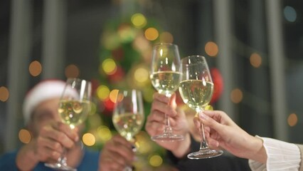close up glasses of clinking glasses of champagne with lighting. Party of asian friend female and male celebrating. happiness friends christmas eve celebrate dinner party with food and champagne.