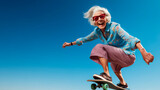 Fototapeta  - Charming funny older woman dressed in fashionable attire, skillfully using skateboard against backdrop of blue sky