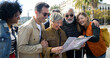 © gonzagon - Group of diverse middle aged friends looking at a map during vacation in a city