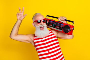 Poster - Photo of grandfather in swimwear show v sign symbol at vacation egypt resort party liste sound boombox isolated on yellow color background