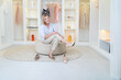 © neirfy - Blond senior woman in casual clothes standing at wardrobe in room or clothing shop and choosing dress for dinner date or party with friends, dress retail shop owner. People and fashion concept