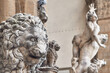 Close-up lion statue in Piazza della Signoria in the Loggia dei Lanzi, in the background sculpture of the Rape of the Sabine Women by Giambolgna in Florence