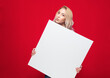 Surprised promoting women holding white board, isolated on red background. Girl showing blank empty paper billboard with blank space for text