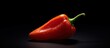 © MUCHIB - Red hot pepper with drops of water on a black background.