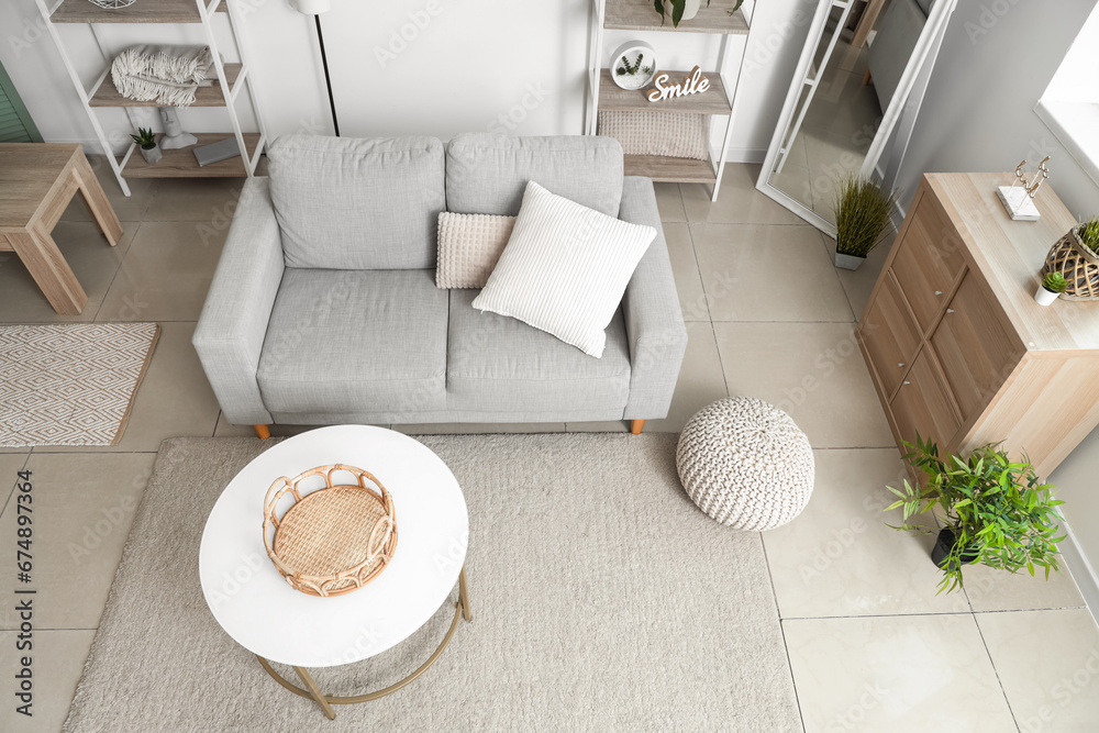 Interior of light living room with grey sofa and table, top view