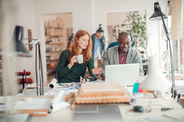 Two young business people having a discussion on a new design project