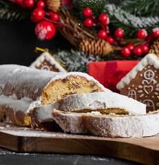 Canvas Print - Christmas pastries stollen sprinkled with powdered sugar on the table, festive dessert