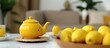 Yellow tea set and lemons on white table and background, selective focus, blurry
