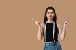 Beautiful young sporty woman with measuring tape and cutlery on brown background. Weight loss concept