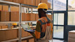 African american man checking goods on laptop, reviewing stock logistics for merchandise on shelves. Male depot employee working on inventory in storage room, retail store orders.