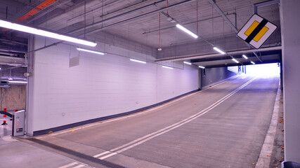 Wall Mural - Underground parking under shopping center. Car parking garage with lighting and columns.