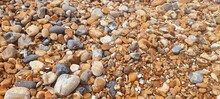 Close-up Shot Of A Beach Shoreline Featuring A Variety Of Small Pebbles And Rocks