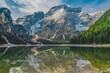 Scenic shot of rocky mountains reflected on the waters of a still pond in a park
