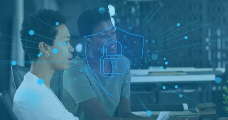 Poster - Animation of padlock in shield over diverse female coworkers discussing reports on laptop in office