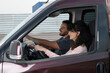 © New Africa - Driving school. Happy student passing driving test with examiner in car