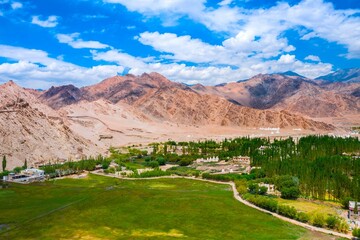 Wall Mural - Beautiful view of a lush green valley with a range of mountains in the background