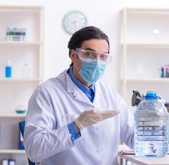 Wall Mural - Young male chemist experimenting in lab