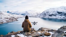 Adult Male Man Traveller Using Smartphone And Remote Control Drone For Taking Aerial Topview Landscape Photograph While Travel Vacation In Snow Mountain And Ice Lake Winter Time