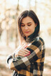 © Mila - A beautiful girl in jeans and a plaid shirt walks in a birch grove. Portraits of a brunette girl in nature, in the autumn forest