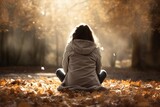 Fototapeta  - Mujer sentada en el suelo en un bosque de otoño. Está cabizbaja. Parece que tiene alguna preocupación o está relajada