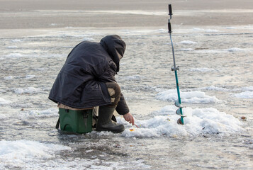 Sticker - A man with a drill on the ice while fishing