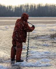 Sticker - A man with a drill on the ice while fishing