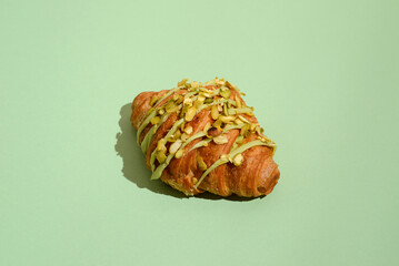 Wall Mural - croissant with pistachio on a green background
