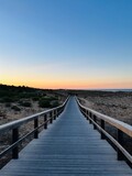 Fototapeta Na drzwi - Boardwalk to the ocean, orange horizon, blue pure sky, no people