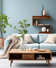 Wooden coffee table near blue sofa, book shelf on the wall. Scandinavian home interior design of modern living room.