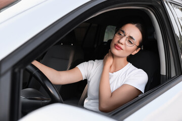 Canvas Print - Young woman suffering from neck pain in her car