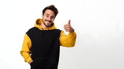 Young smiling happy unshaven caucasian man wear black yellow hoody look camera point index finger aside indicate on workspace area copy space mock up isolated on plain solid white background studio po