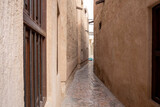 Fototapeta Uliczki - View of narrow clean streets between traditional stone buildings in old city Souk Madinat Jumeirah, Al Fahidi, Dubai, UAE, United Arab Emirates 