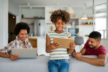 Wall Mural - Obsessed to tech devices happy african american family using digital tablet, computer, smartphones