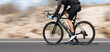 Motion blur of a bike race with the bicycle and rider at high speed. Professional male cyclist in racing outfit during a ride on bike outdoors. Panning technique used