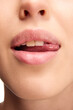 © Lustre Art Group  - Open mouth, tongue touches teeth. Close up view of woman licking pink natural gloss lips. Beautiful plump lips.