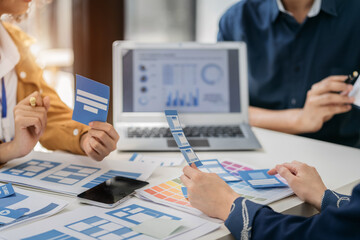Creative team web designer planning application development for web mobile phone with customer breif and color code at office.