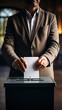 Hand of a man voting at a ballot box during elections
