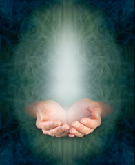 Sending love and blessing heart healing vibes concept - female cupped hands in ethereal green oval with rising white energy  and dark blue border with copy space all around ideal for spiritual wall ar