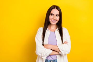 Wall Mural - Photo portrait of attractive young woman look empty space folded arms dressed stylish white clothes isolated on yellow color background