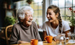 © Bartek - Bubbly Carer Shares Laughs with Spirited Elderly Woman in Kitchen