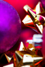 Extreme Close Up Of Red And Purple Christmas Baubles And Gold Bows
