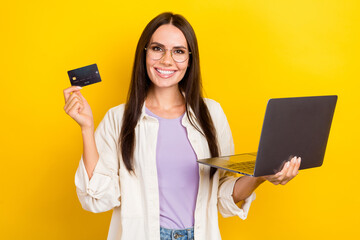 Sticker - Photo portrait of attractive young woman hold netbook credit card dressed stylish white clothes isolated on yellow color background